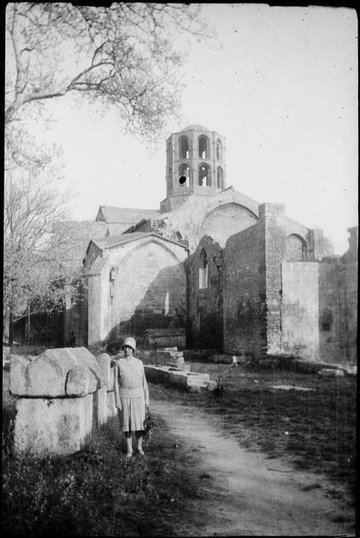 Eglise Saint-Honorat : façade et clocher côté nord-ouest et femme au premier plan