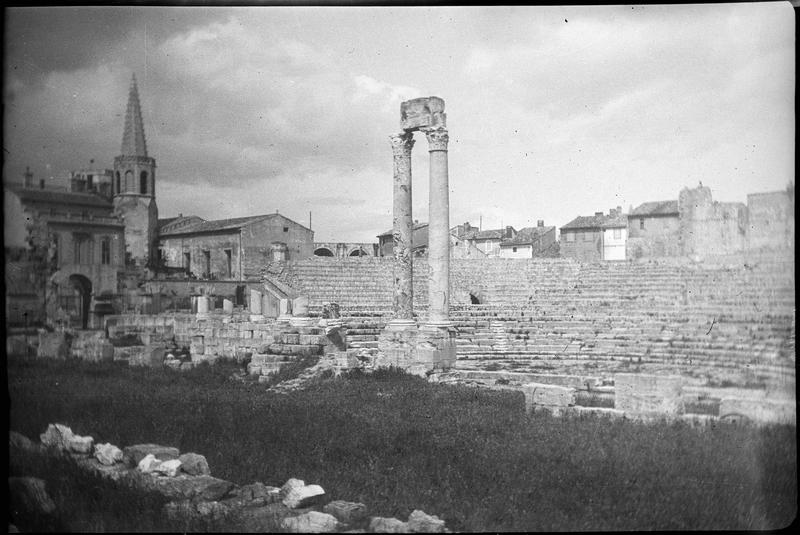 Ensemble en ruines avec les deux colonnes du mur de scène et les gradins, coté sud et clocher de l'école Saint-Charles en arrière-plan