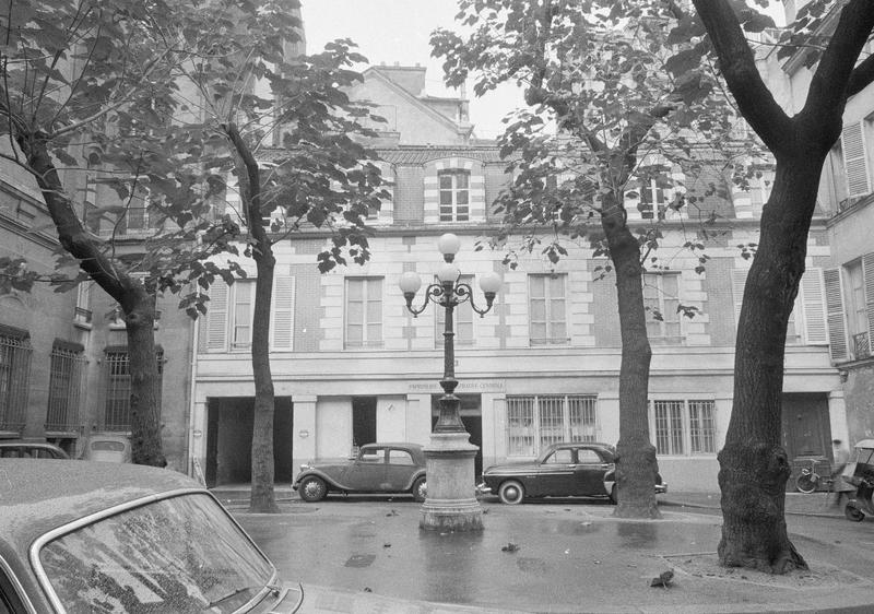 Façades sur place centrale avec lampadaire et voitures stationnées