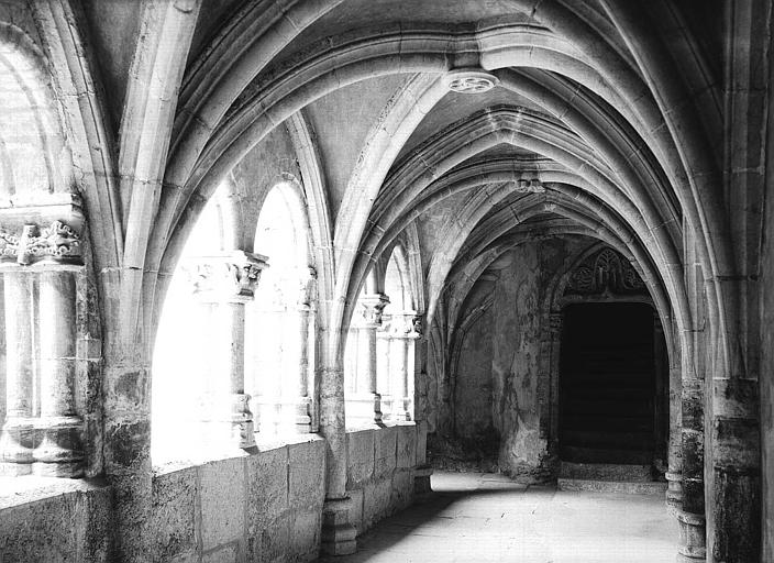 Cloître : vue intérieure de la galerie est vers la porte conduisant à l'église