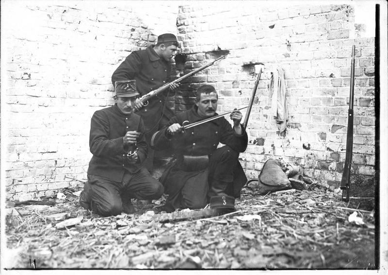 Trois soldats belges avec leurs fusils dans un abri