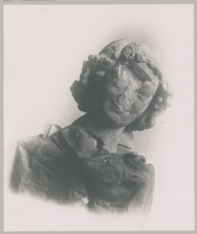 Statue : tête de l'ange au sourire, de face, détruite par les bombardements ; Assemblage de neuf morceaux après les restitutions de juillet 1916