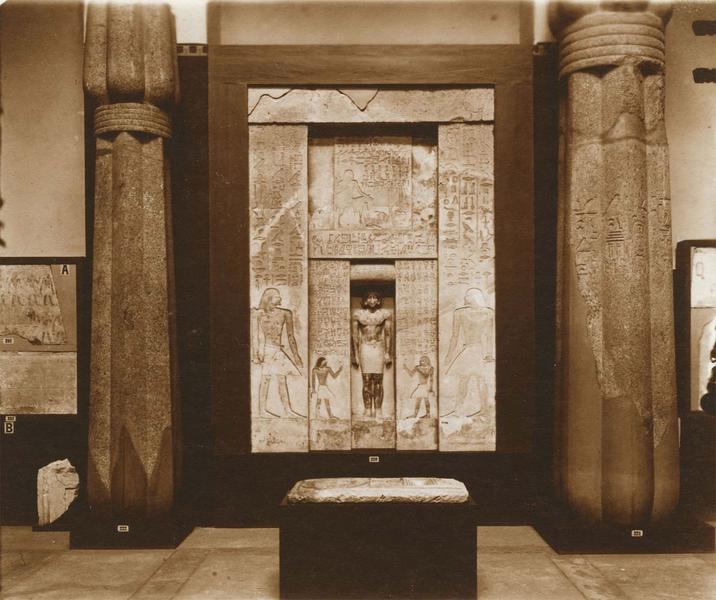 Intérieur d'une salle : stèle d'Atoti. Le défunt est debout dans l'embrasure de la fausse porte, prêt à recevoir l'offrande. Calcaire 3,40m x 2,20m, Saqqara