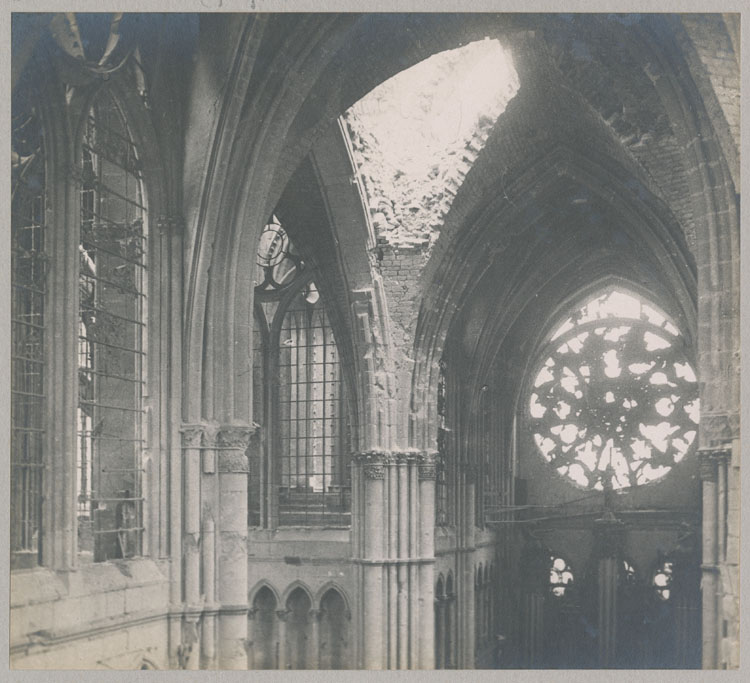 La voûte de la croisée du transept crevée par les bombardements, depuis les fenêtres hautes du croisillon sud ; À droite, la rose du croisillon nord