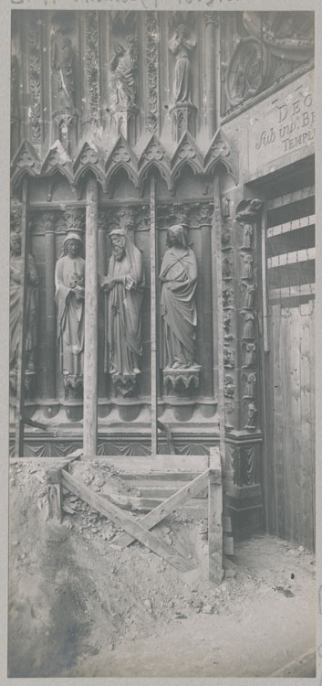 Façade ouest, porche central : ébrasement gauche après l'enlèvement des sacs de protection ; Groupe de la Présentation au Temple : statues de la Vierge à l'Enfant, Siméon et Anne