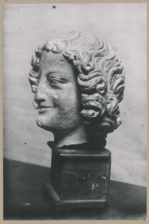 Statue : tête d'ange souriant, profil gauche, provenant du porche nord de la façade ouest de la cathédrale