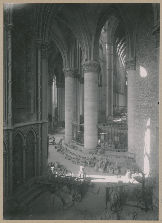 Le déambulatoire et le choeur depuis la chapelle axiale ; À droite, le mur de séparation de l'église provisoire ; Au sol, dépôt lapidaire de pierres ornementales