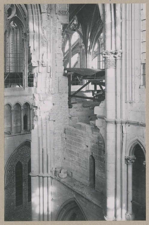 Le pilier sud-est de la croisée du transept détérioré par les bombardements et consolidé, depuis les fenêtres hautes du croisillon sud ; Chantier ; Échafaudage