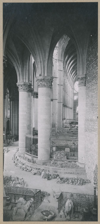 Le déambulatoire et le choeur depuis la chapelle axiale ; À droite, le mur de séparation de l'église provisoire ; Au sol, dépôt lapidaire de pierres ornementales