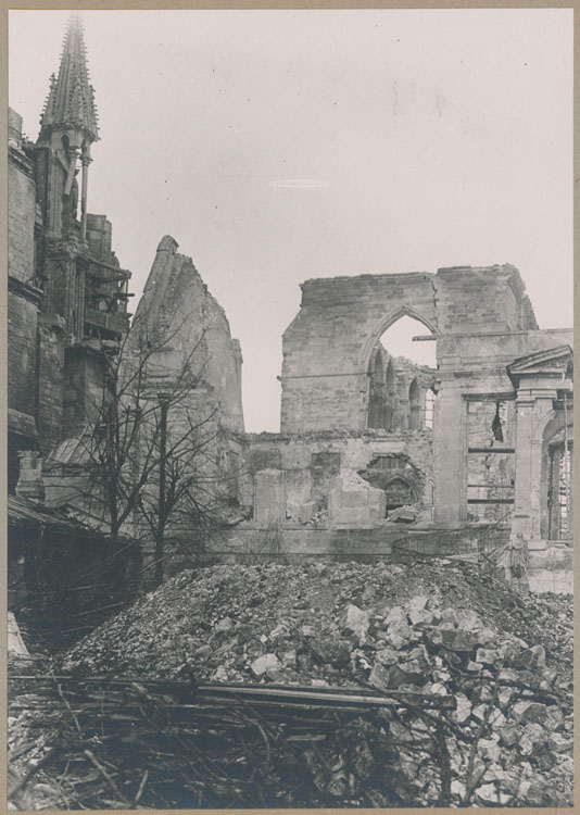 Façade ouest : la salle du Tau et la chapelle archiépiscopale, vues de la cour d'honneur, après les bombardements ; À l'arrière-plan, le chevet de la cathédrale