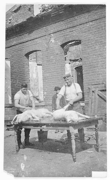 Soldats allemands dans une ferme en France, dépeçage du cochon