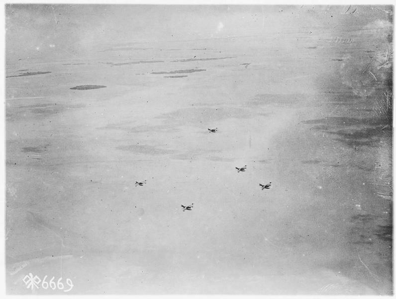 Photo aérienne prise près d'une base américaine. Cinq avions volant à 2000 pieds sont pris en photo par un 6ème volant à 1300 pieds plus haut