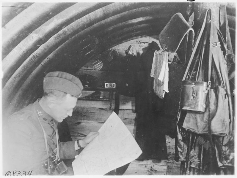 Intérieur d'un abri, militaire lisant le journal