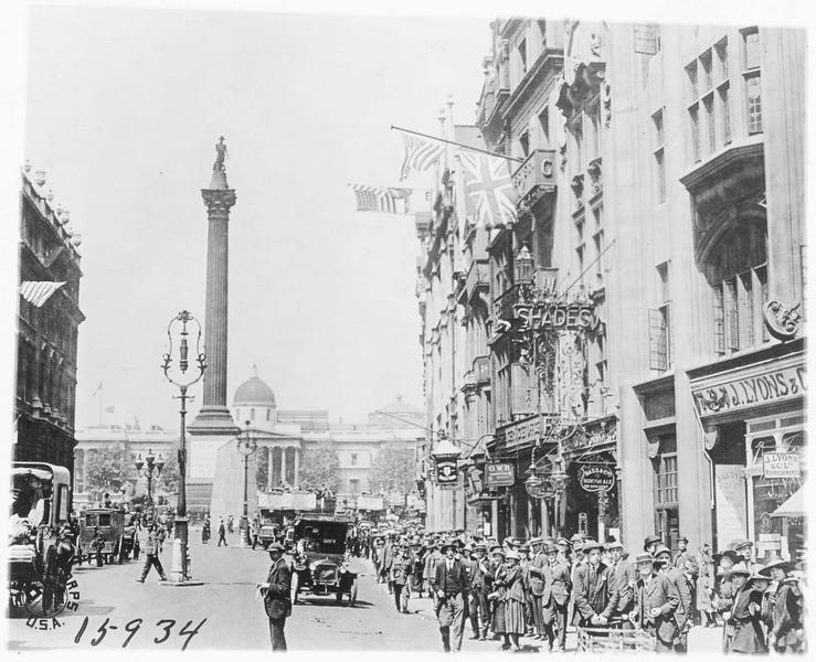 Une rue animée et pavoisée près de Trafalgar Square. Vue de la colonne Nelson