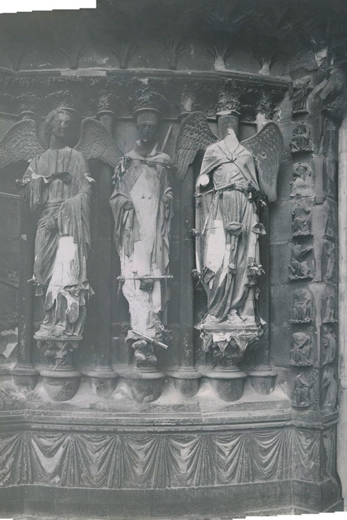 Panorama reconstitué : façade ouest, porche nord, ébrasement gauche : statue de Nicaise entouré de ses anges ; À droite, l'ange au sourire décapité par les bombardements