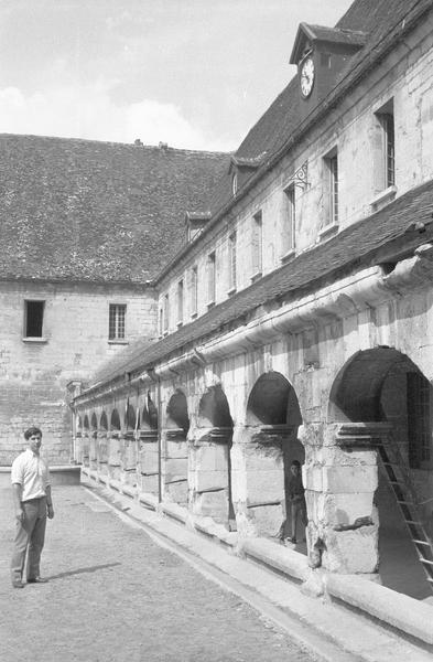 Cloître : galerie de l'aile nord, vue en perspective depuis la cour et homme