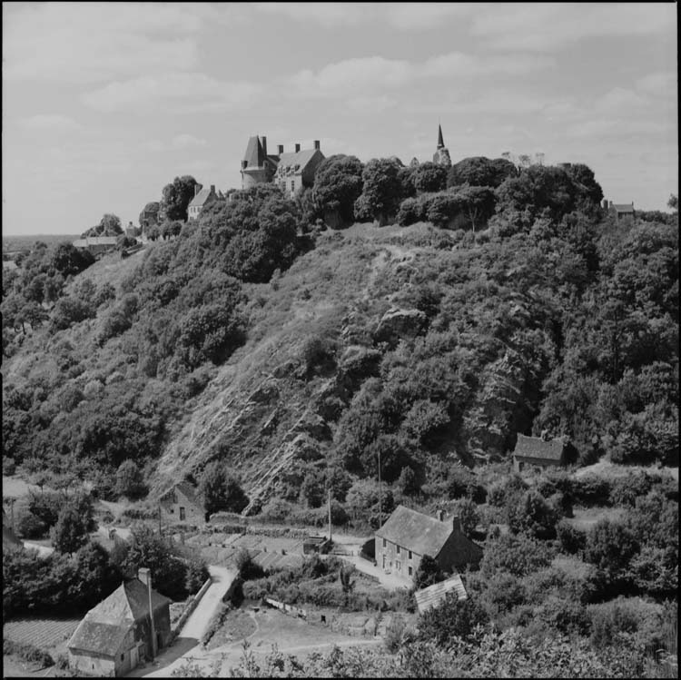 Vue des hauteurs du village ; clocher et château, habitations en contrebas