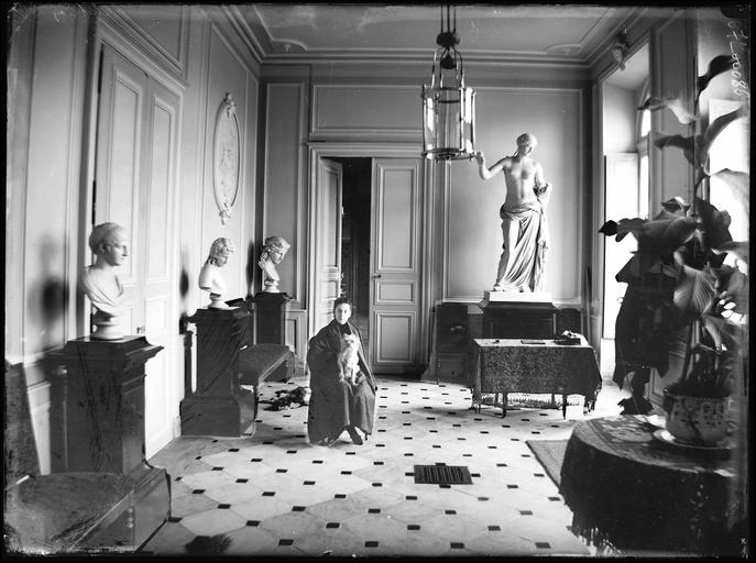 Intérieur : femme assise avec un chien dans une galerie