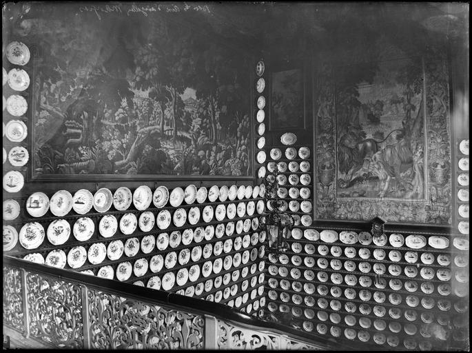 Exposition d'assiettes de faïence dans une cage d'escalier