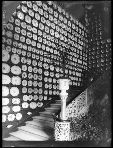 Exposition d'assiettes de faïence dans une cage d'escalier