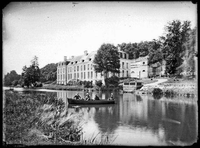 Façade sur la rivière, personnes dans une barque