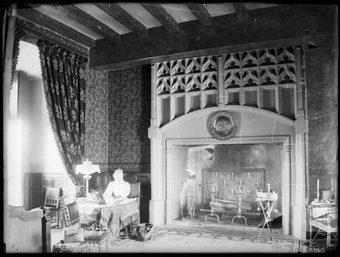 Intérieur : femme assise à un bureau, cheminée