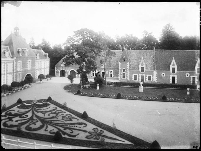 Château et communs sur parc, parterre de fleurs au premier plan