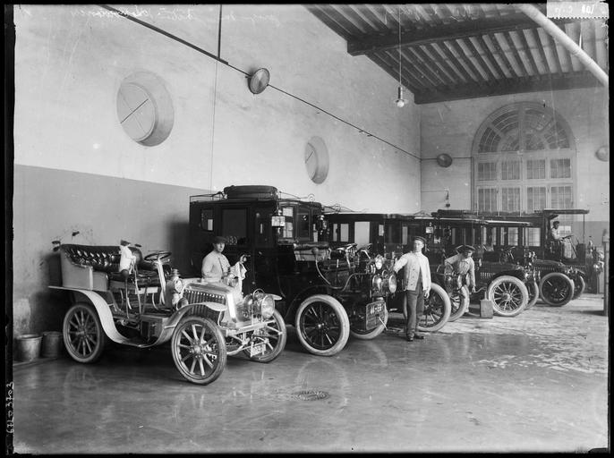 Alignement d'automobiles dans un garage, chauffeurs