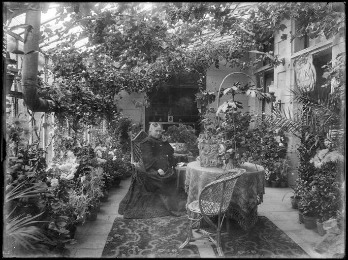 Une dame assise dans le jardin d'hiver