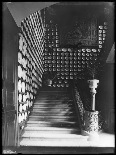 Exposition d'assiettes de faïence dans une cage d'escalier