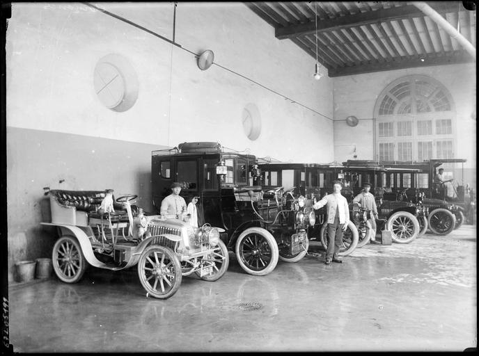 Alignement d'automobiles dans un garage, chauffeurs