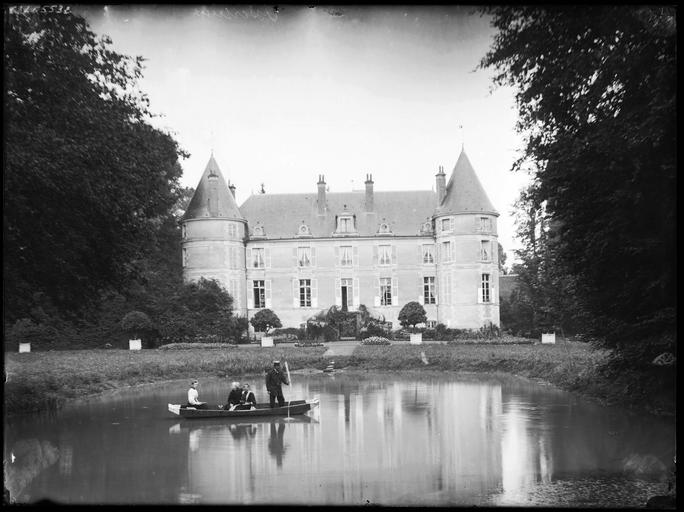 Façade sur parc, personnes dans une barque sur un étang