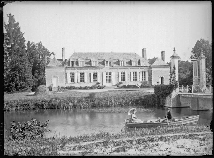 Ensemble avec portail d'entrée et pont, barque sur la rivière au premier plan