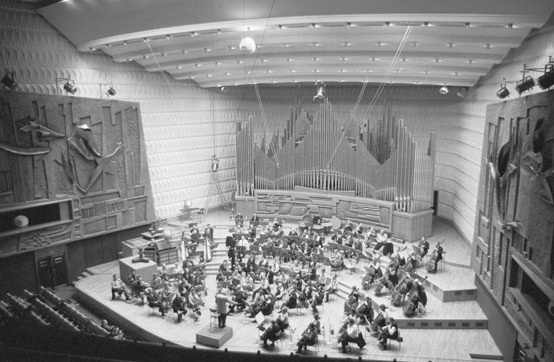 Intérieur : salle de concert dite studio 104, scène avec grand orgue et musiciens, vue en plongée