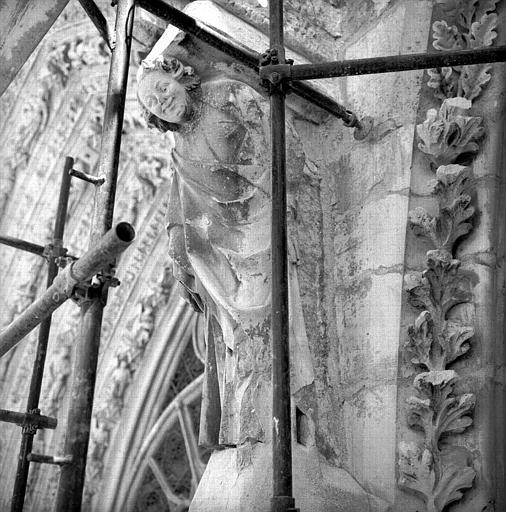 Façade ouest, portail sud, tête entre les ébrasements des portails central et sud, figure en console au départ des gables