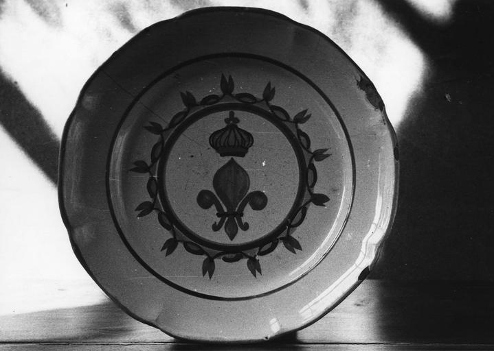 Assiette en faïence à décor de fleur de lys couronnée placée au centre d'un médaillon, l'ensemble peint en bleu, jaune, vert et orange sur fond blanc - © Ministère de la Culture (France), Médiathèque du patrimoine et de la photographie (objets mobiliers), tous droits réservés