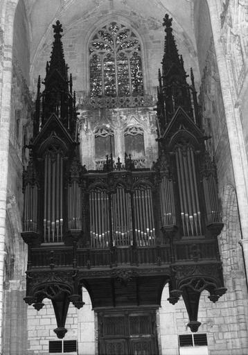 Partie instrumentale de l'orgue au décor sculpté  reprenant l'architecture d'une église gothique, avec pignons et pinacles, bois sculpté