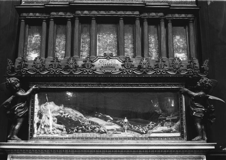 Reliquaire de sainte Valentine : détail de la partie inférieure composée d'une vitrine encadrée par deux angelots, dans laquelle est allongée une statue (?) à l'effigie de la sainte