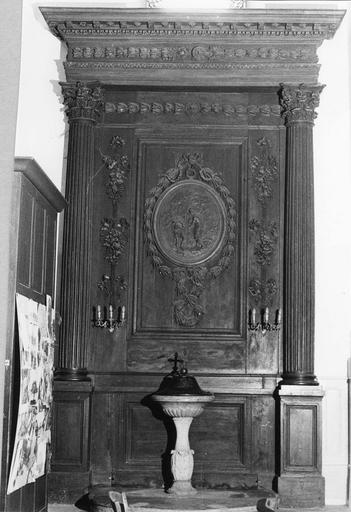 Lambris architecturé au panneau central sculpté d'un médaillon représentant le Baptême du Christ, de guirlandes de feuillages et de chutes de fruits, bois sculpte