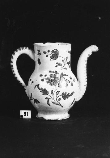 Cruche à long goulot coudé, au décor de bouquets de fleurs et fleurettes isolées sur fond blanc, faïence