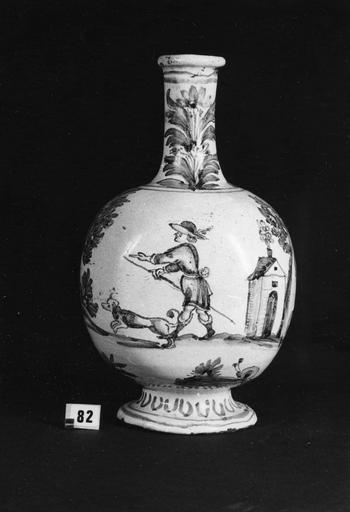 Pot à pharmacie (bouteille) orné d'une scène représentant un homme sortant de chez lui avec son chien, col au décor de fleurs, faïence (devant) - © Ministère de la Culture (France), Médiathèque du patrimoine et de la photographie (objets mobiliers), tous droits réservés