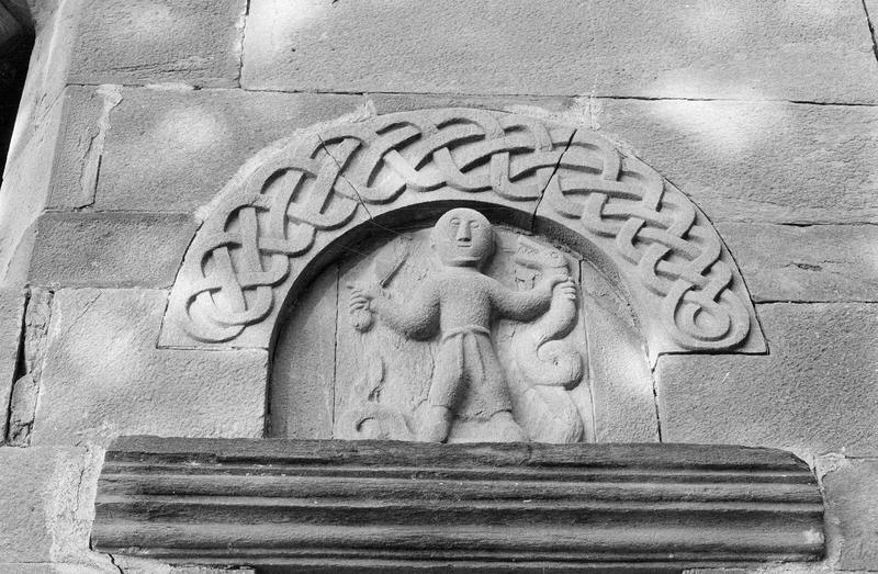 Portail sud, tympan sculpté représentant un homme tenant un serpent et un glaive