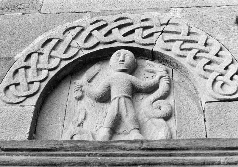 Portail sud, tympan sculpté représentant un homme tenant un serpent et un glaive