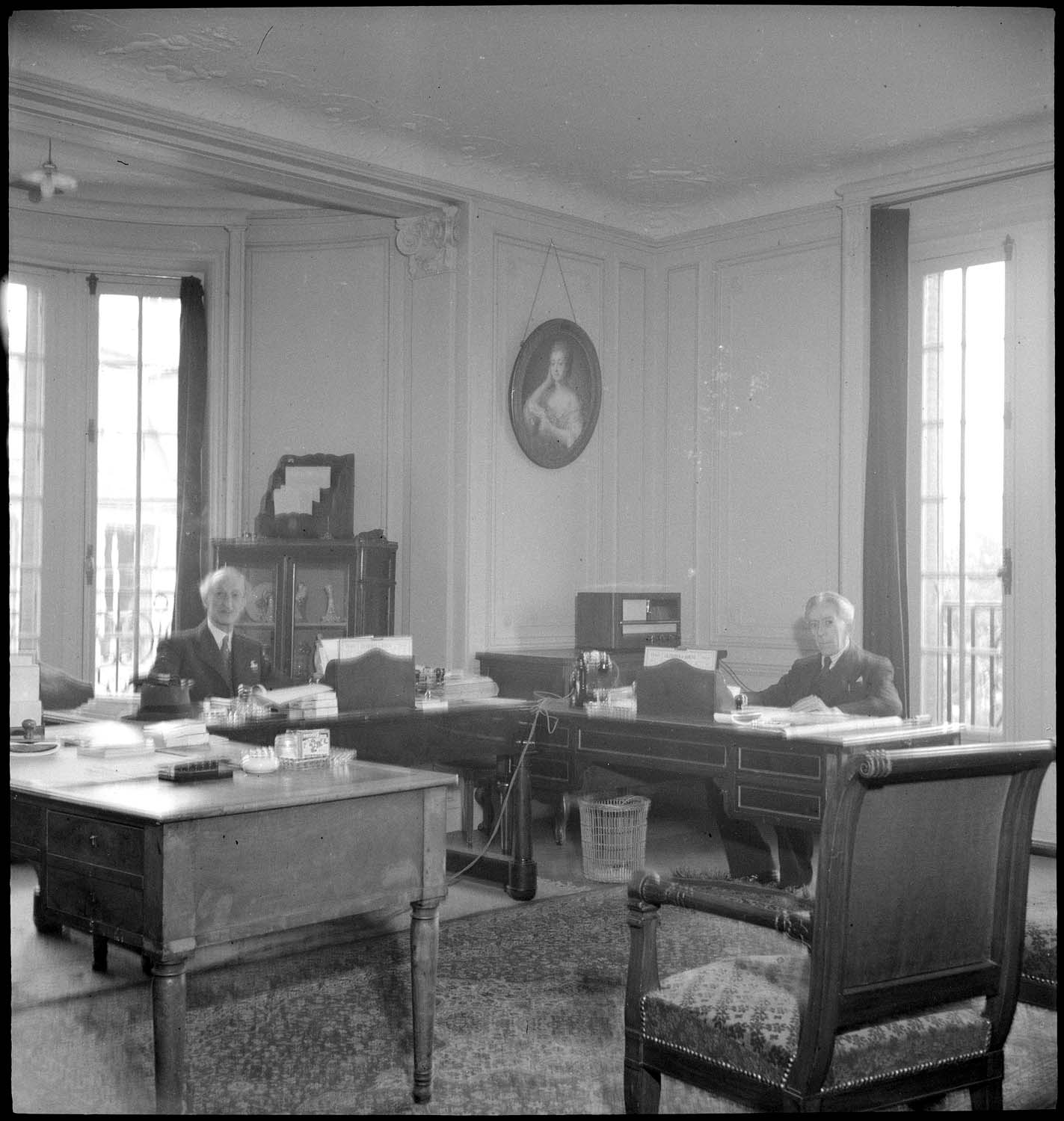 Deux hommes assis à leurs bureaux