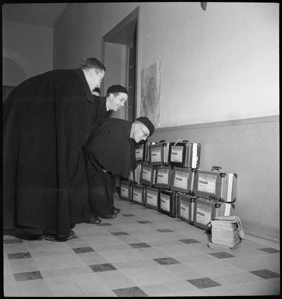 Ordination de prêtres : prêtres regardant les valises destinées au stalag