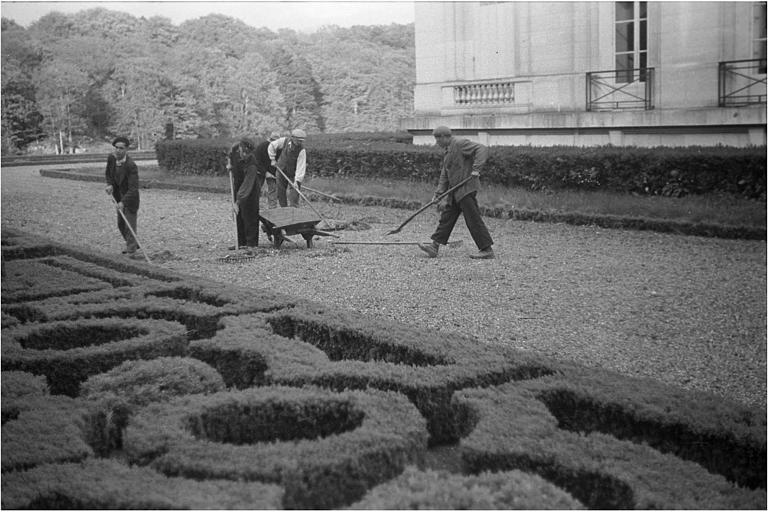 Jardiniers ratissant une allée