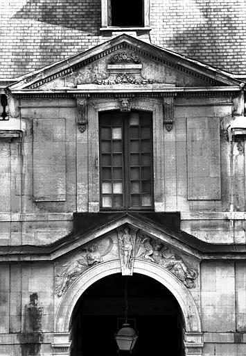 Extérieur, corps central de la façade est : encadrement de la porte cochère et du premier étage, avec l'autorité et deux remontées sur l'arcature de la porte