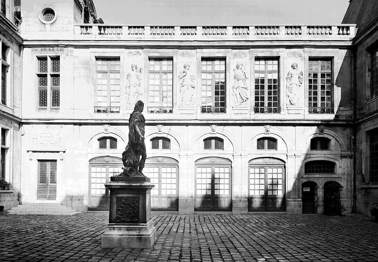 Aile droite extérieure, au-dessus de la porte : génies couchés tenant des palmes, bas-relief imité de celui d'en face/A l'étage, bas-relief