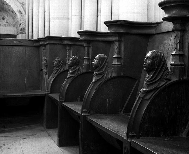 Stalles en bois sculpté, rangée du côté nord : Accotoirs en forme de têtes de moines