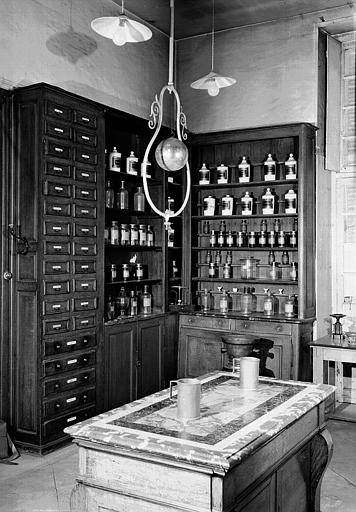 Série de pots de pharmacie sur leurs étagères - © Ministère de la Culture (France), Médiathèque du patrimoine et de la photographie, diffusion RMN-GP